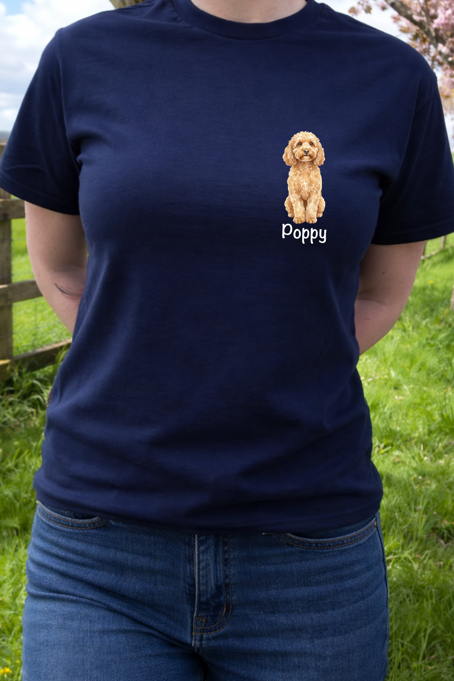 Person wearing a navy blue t-shirt with a dog illustration and 'Poppy' text, standing outdoors.