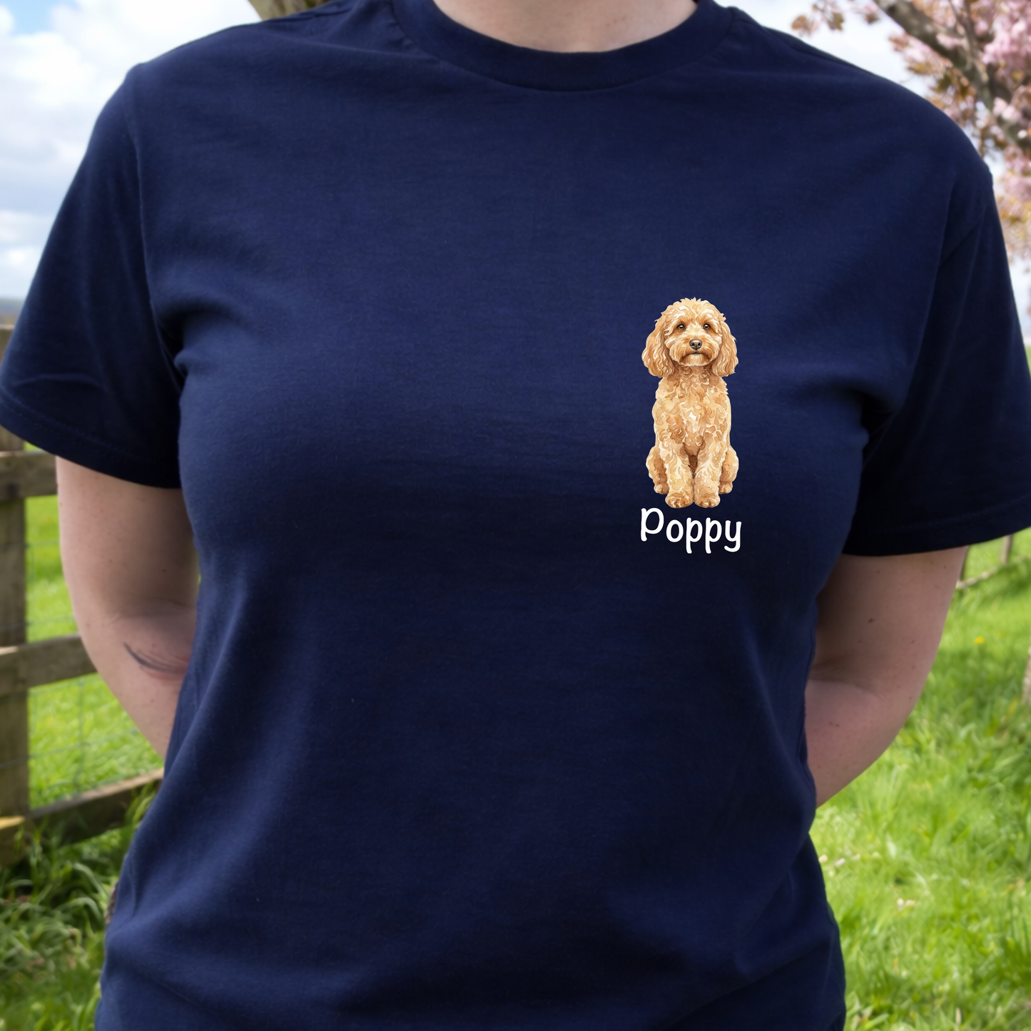 Person wearing a navy blue t-shirt with a dog illustration and 'Poppy' text, standing outdoors.
