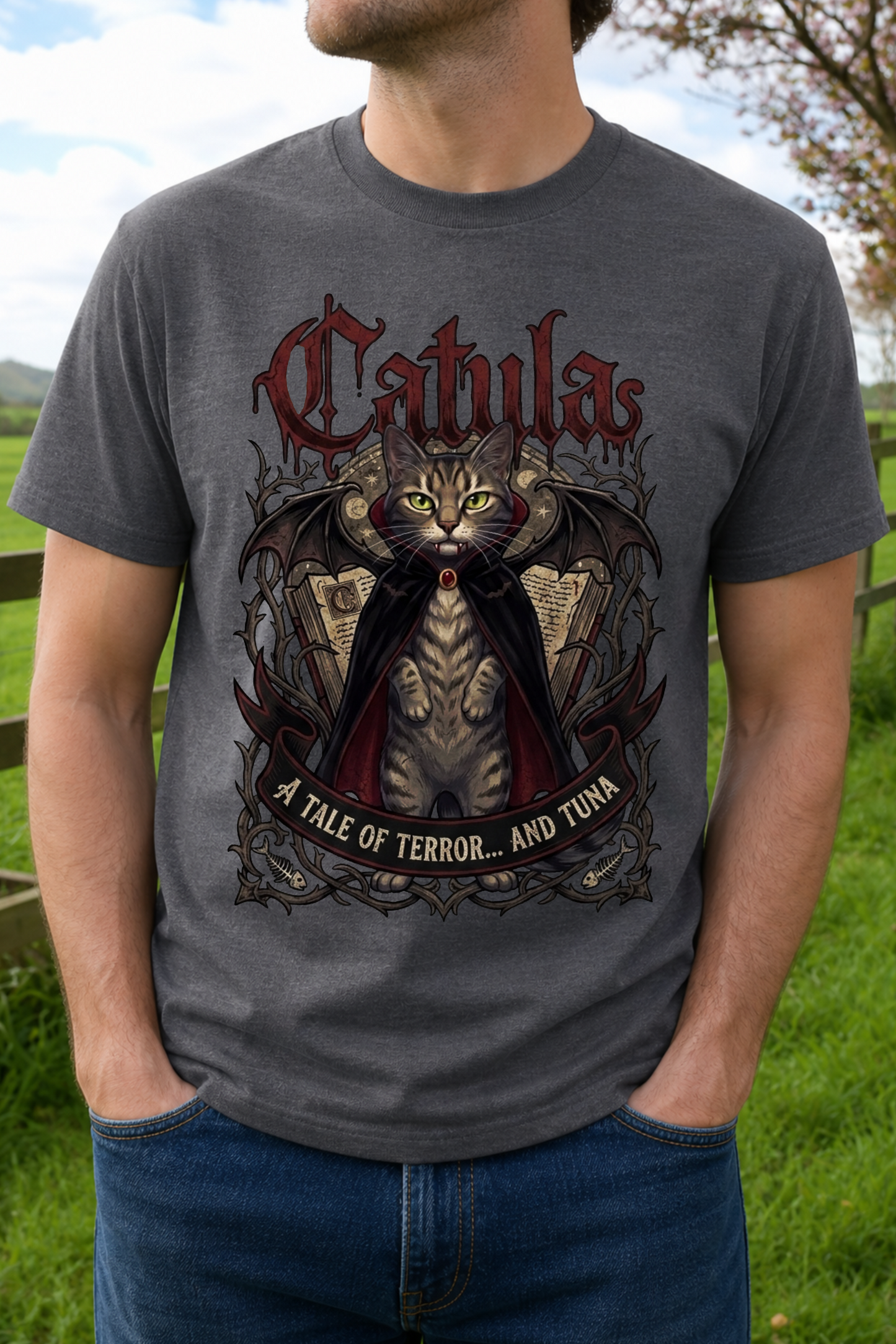 A man wearing a dark gray graphic t-shirt with a gothic cat design and the text 'Cathula' and 'A TALE OF TERROR.