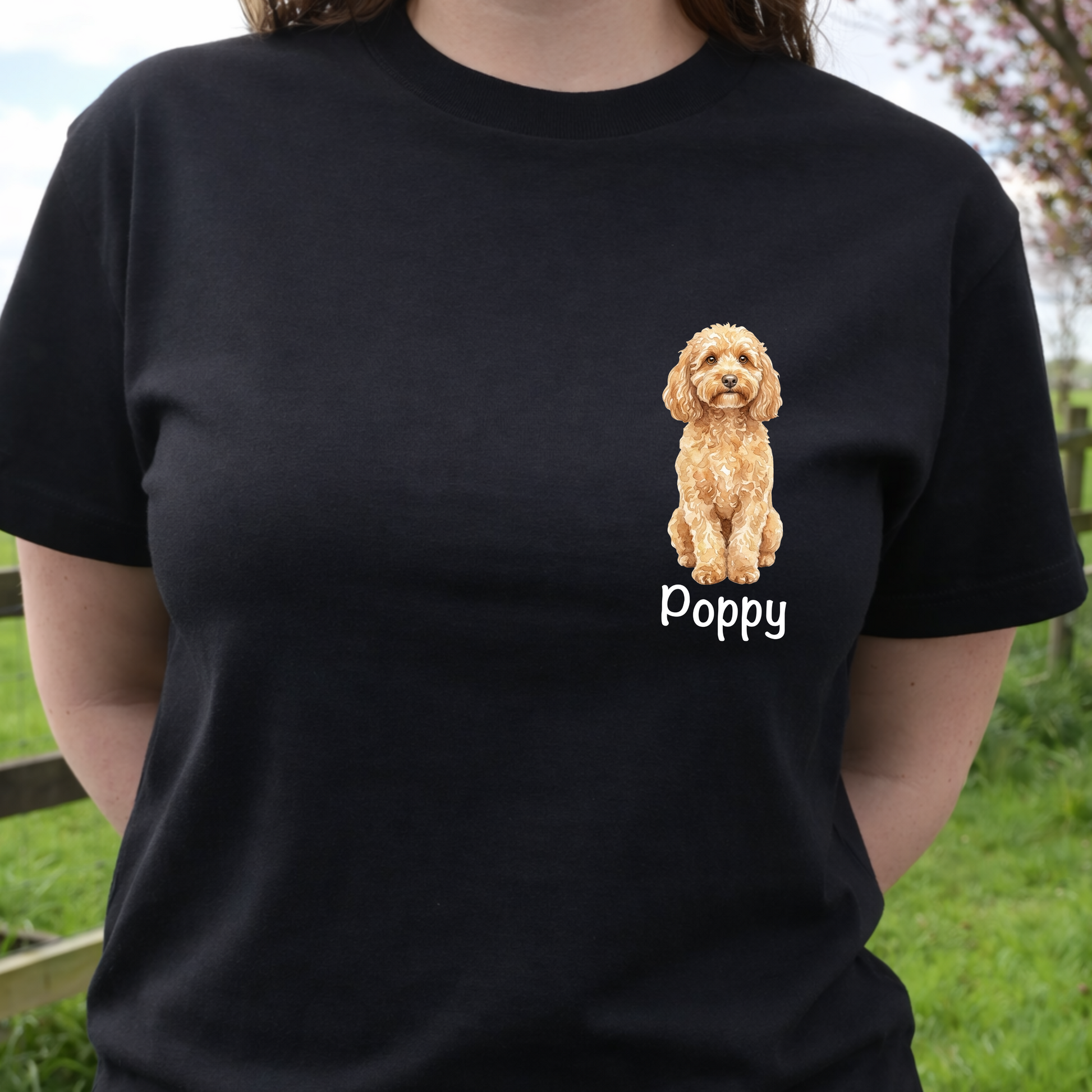 Person wearing a black t-shirt with a dog illustration and 'Poppy' text, standing outdoors.