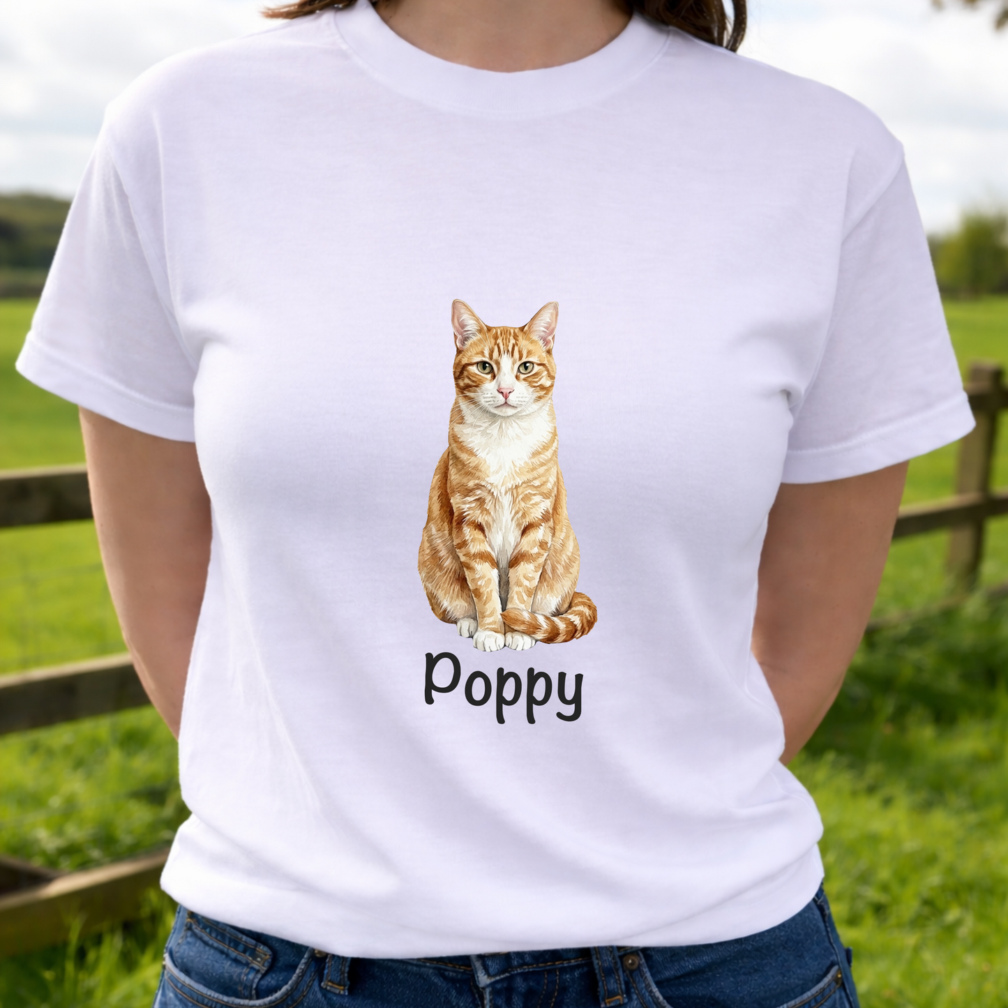 Person wearing a white t-shirt with a cat illustration and 'Poppy' text, standing outdoors.